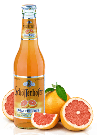 Bottle of beer next to grapefruits