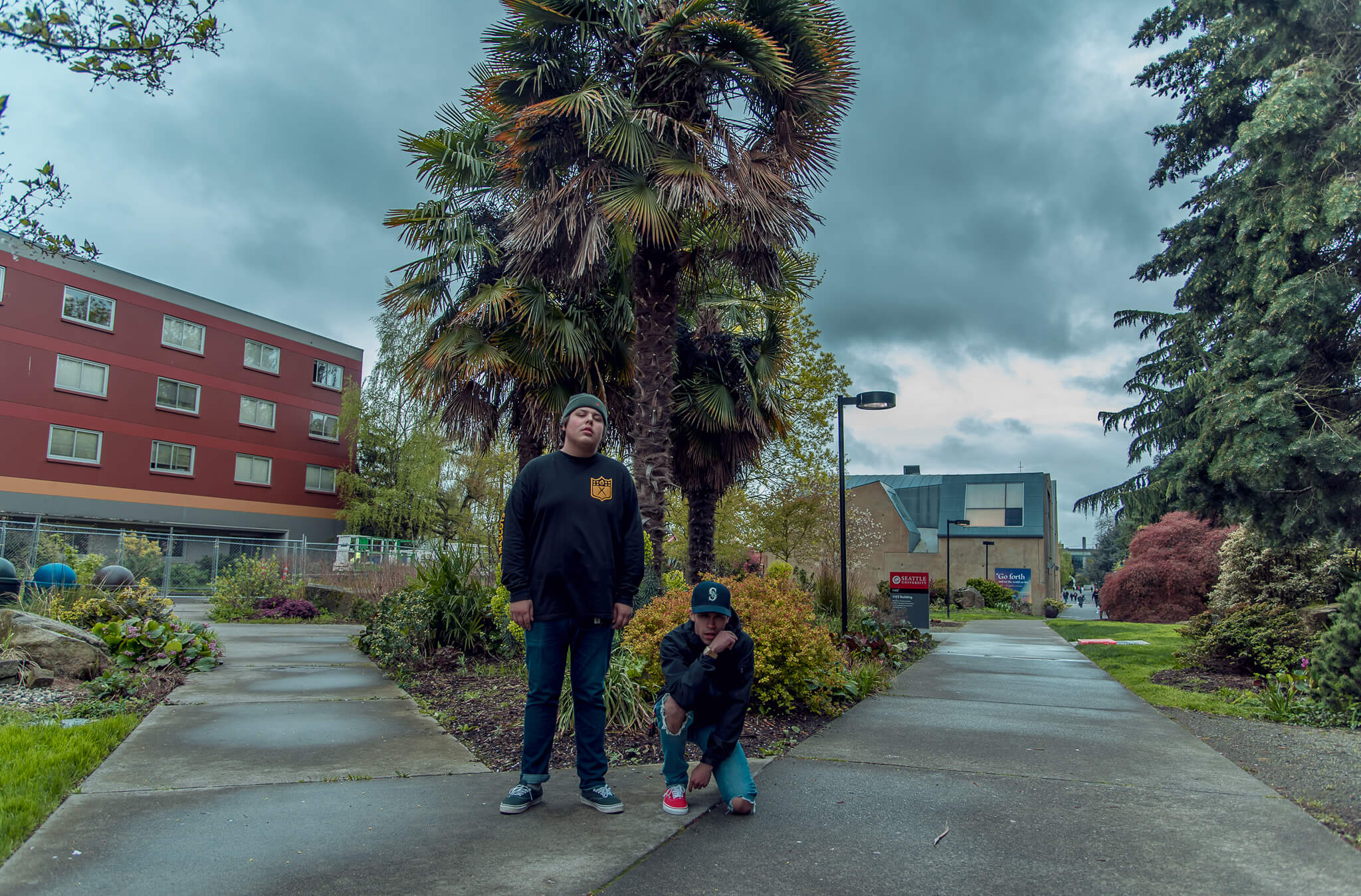 Two guys posing for a photography shot in front of palm trees