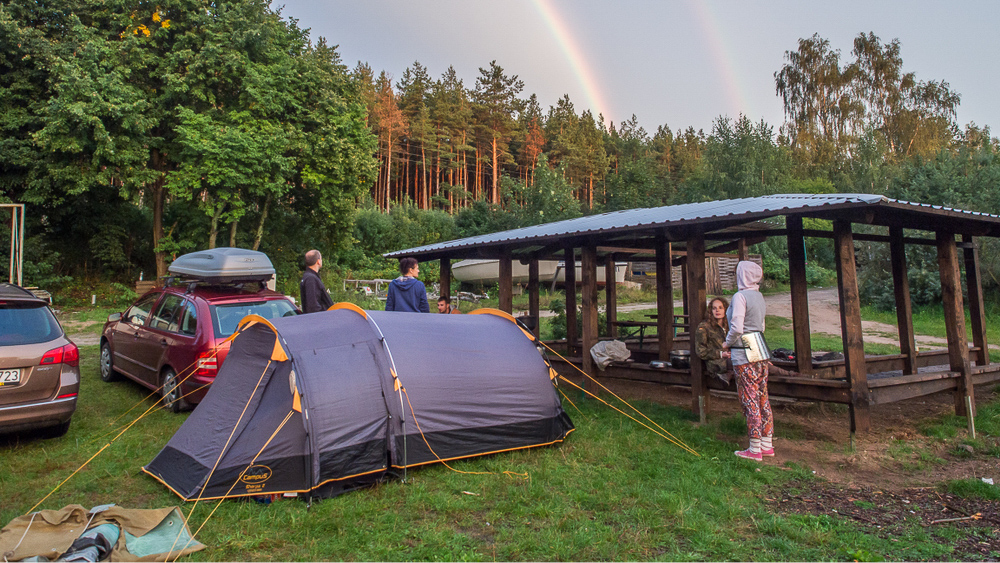 Friends camping under a rainbow