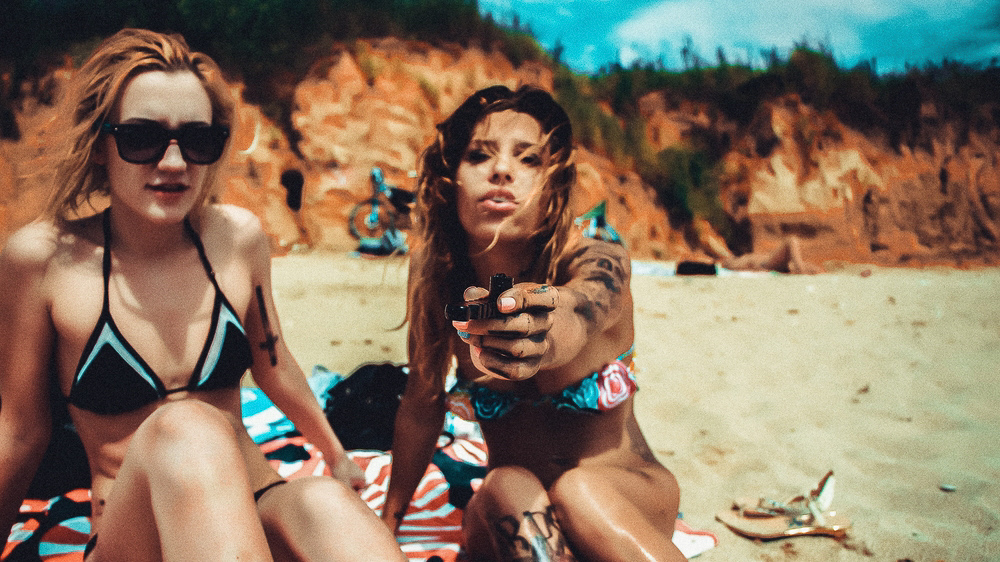 Girls smoking on the beach in swimsuits