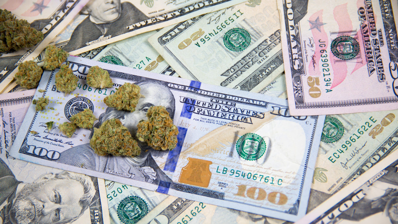 Marijuana bud on top of United States cash money
