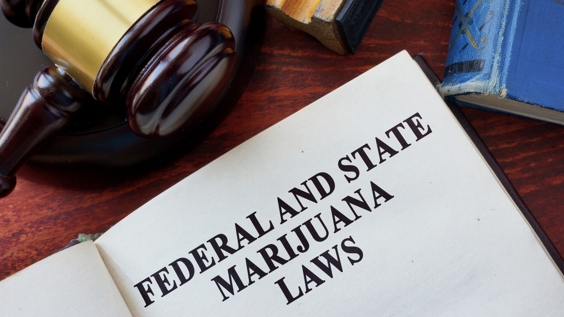 Federal and State Marijuana Laws title on a book and gavel.