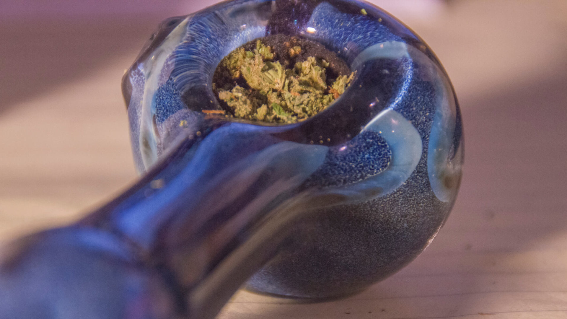 A glass pipe with cannabis buds packed inside.
