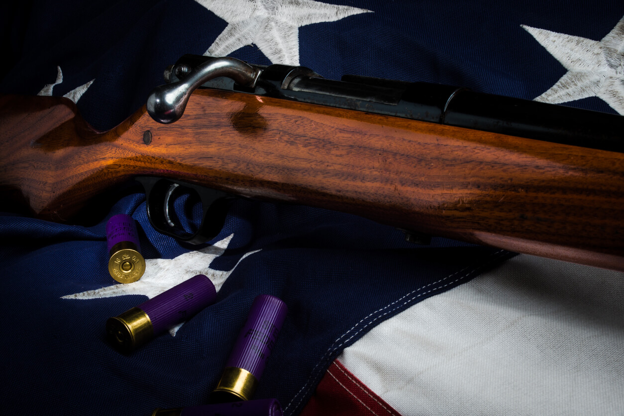 A shotgun backed by an American flag