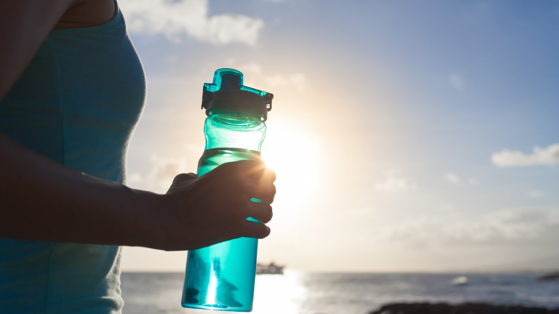 Woman holding water bottle after workout
