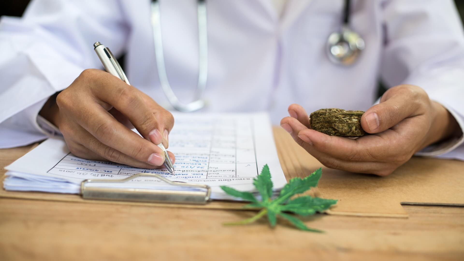 doctor filling out paperwork with cannabis in hand