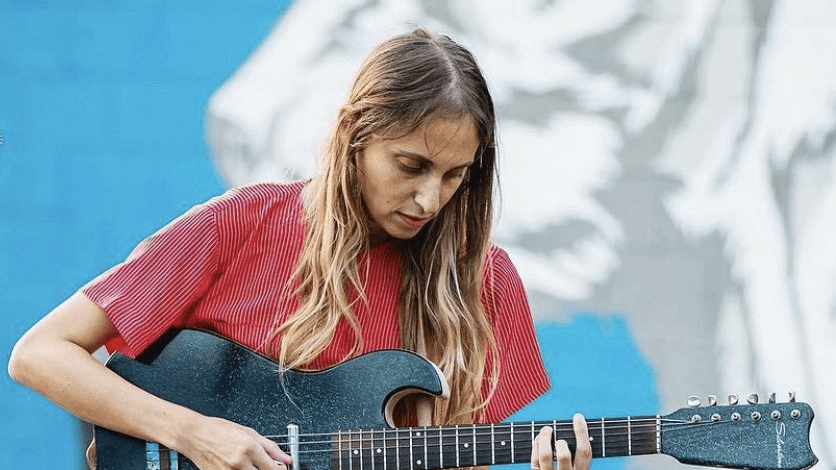 Rachel Goodrich playing guitar at an outside venue