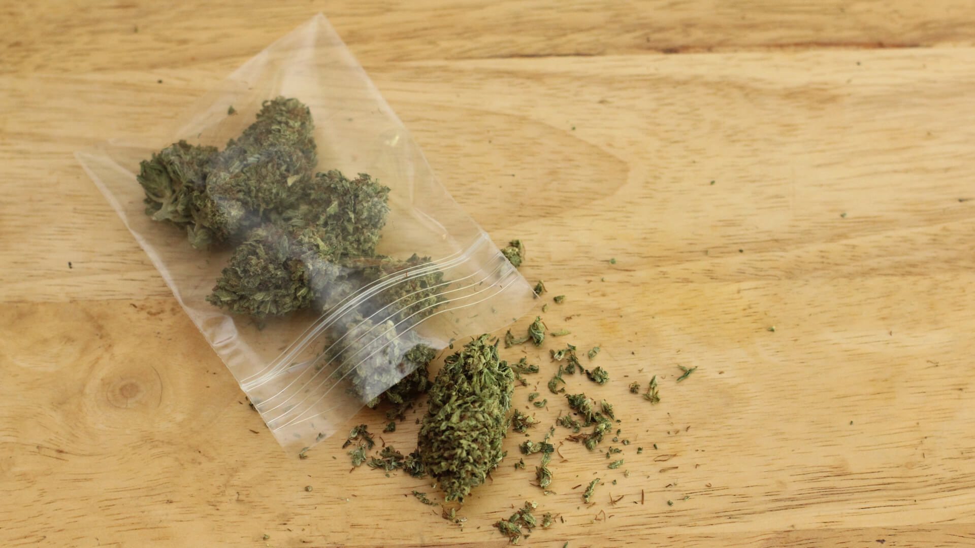 A Dime bag of weed on a wood surface