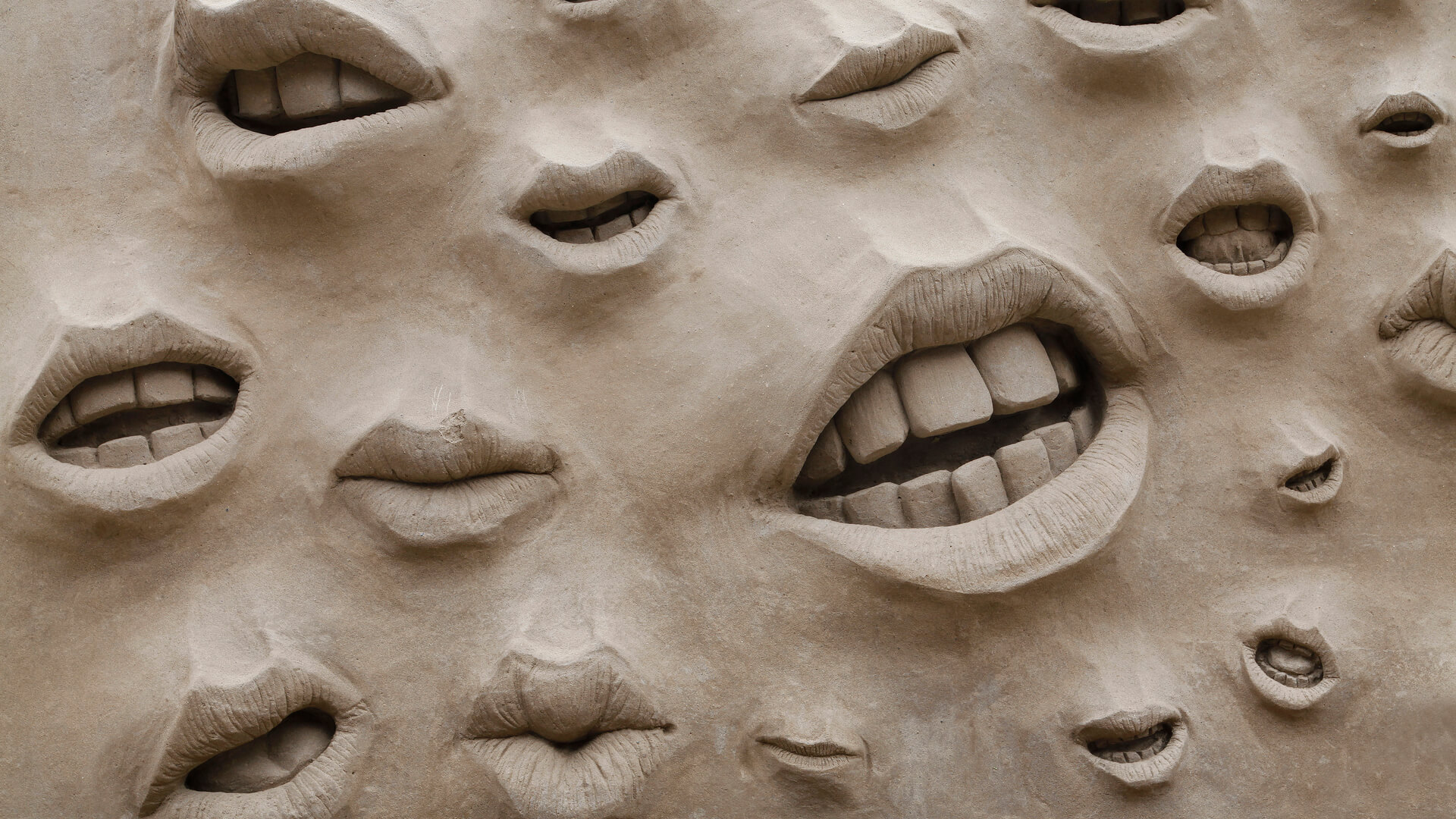 Closeup of mouths on a sand sculpture