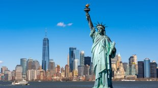Statue of Liberty over scene of New York cityscape