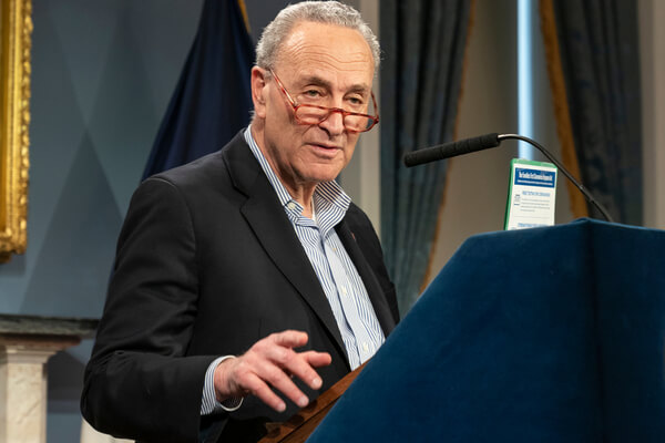 Chuck Schumer at a podium speaking to the media