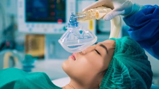 Doctors Anesthetizing a women before surgery