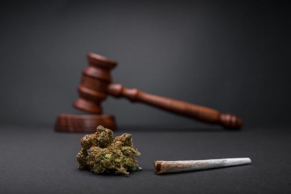 Cannabis nugget and joint in front of a gavel.