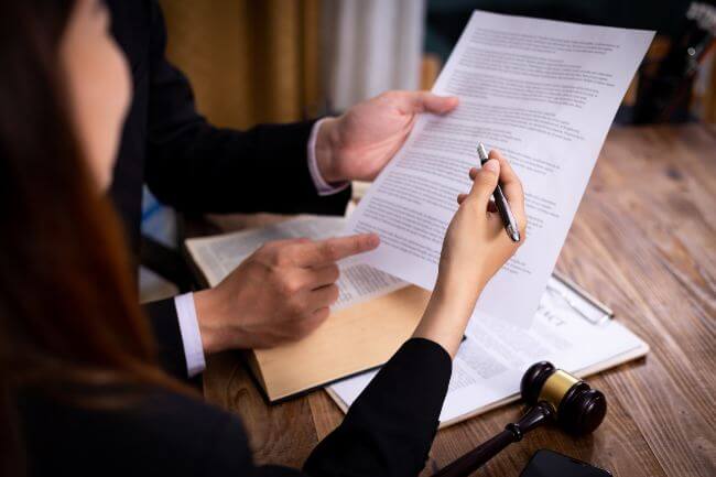 two people look at a document, with a gavel next to them