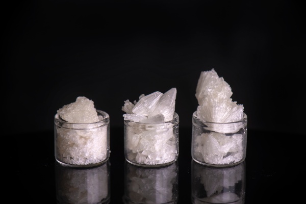 Small, clear jars full of white THC crystallized powdered isolate.