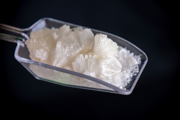 Crystallized white powder in a clear plastic scoop